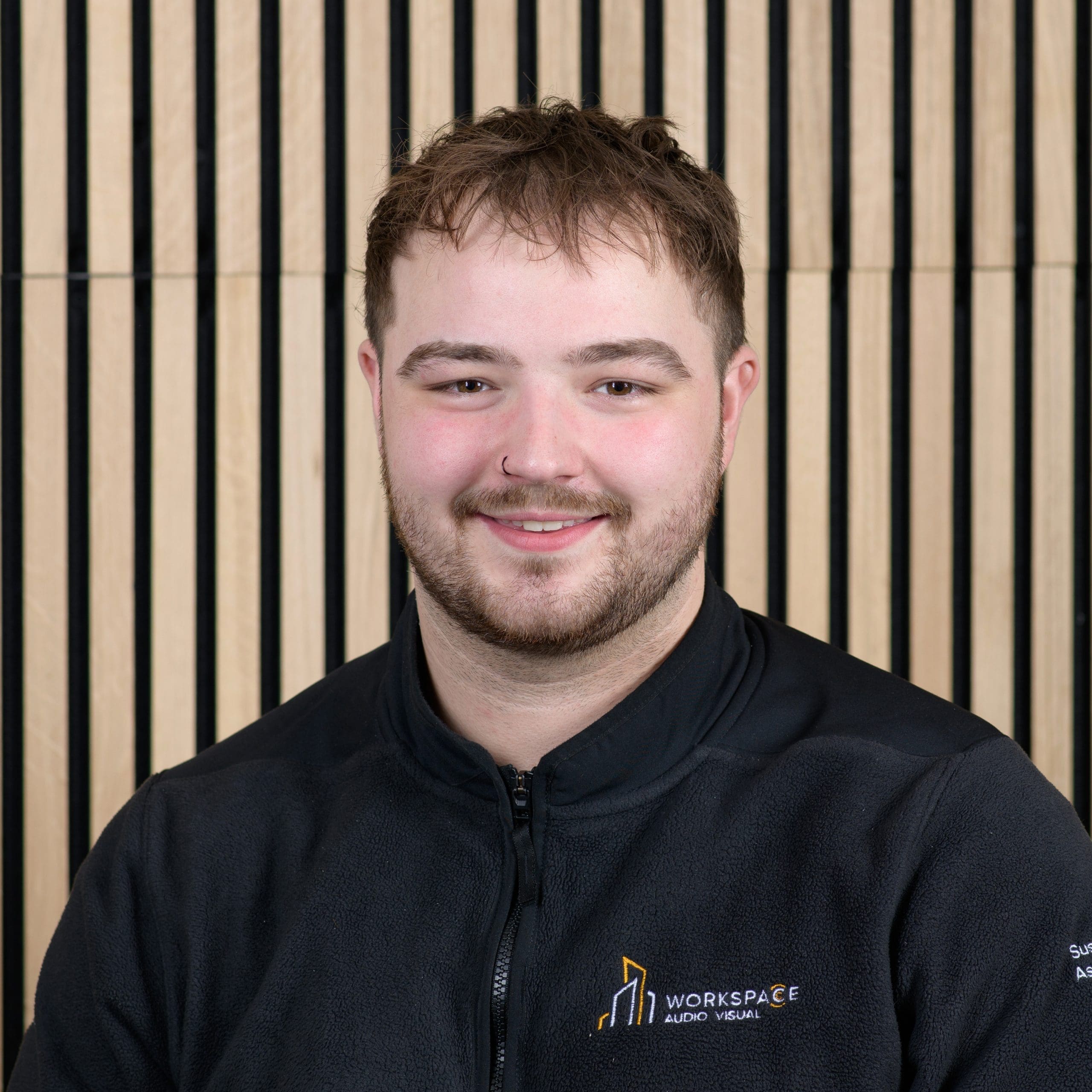 man in a black jacket smiling at the camera