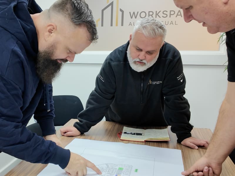 group of men standing around a table