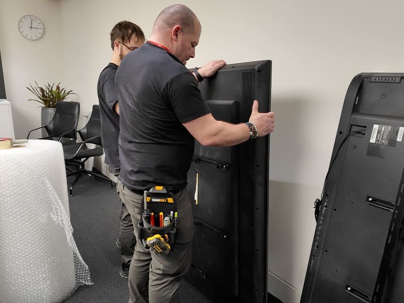 man working on a refrigerator in a room