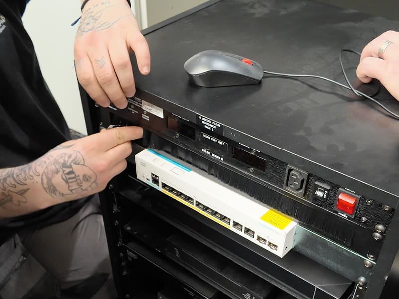 man with a tattoo on his arm working on a computer