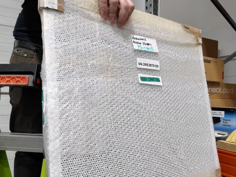 person holding a mattress in a warehouse
