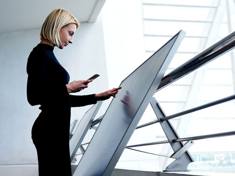 woman using a cell phone while walking up a flight of stairs