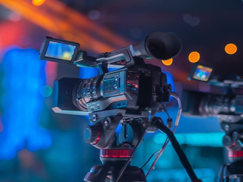 camera set up on a tripod in front of a stage