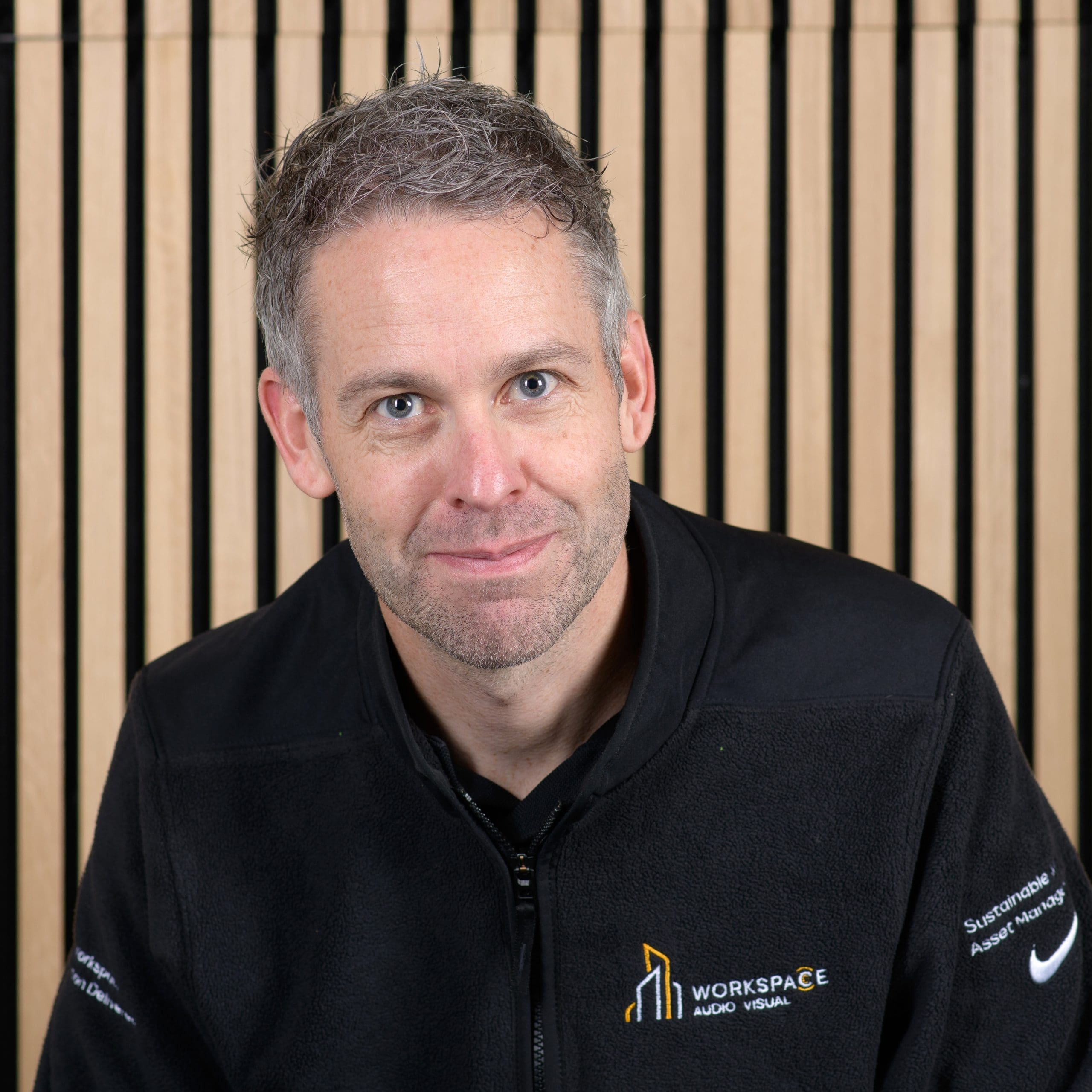 man sitting in front of a wooden wall