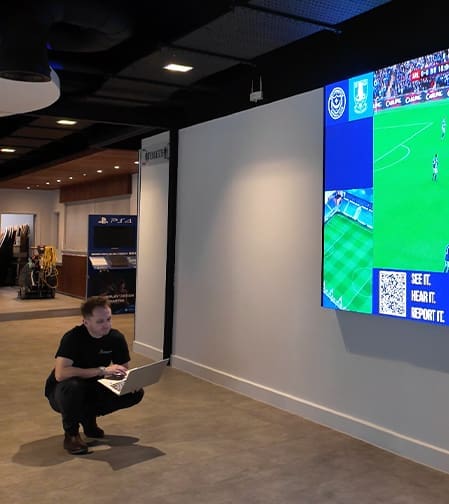 man sitting in front of a TV playing a game