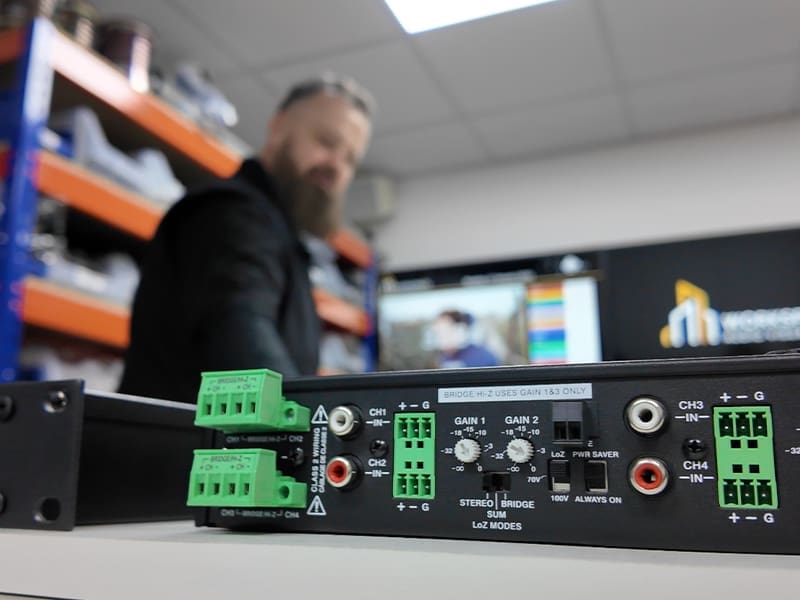man standing behind a control panel in a warehouse