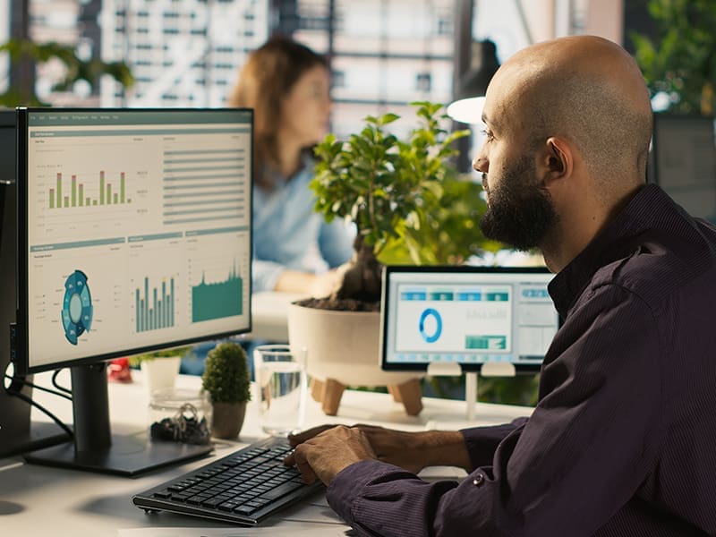 man sitting in front of a computer monitor