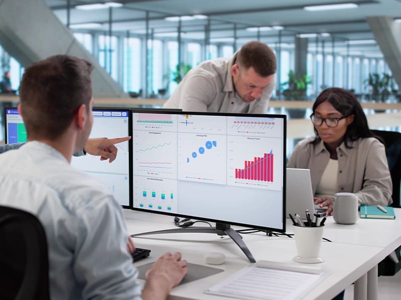 group of people sitting around a computer screen