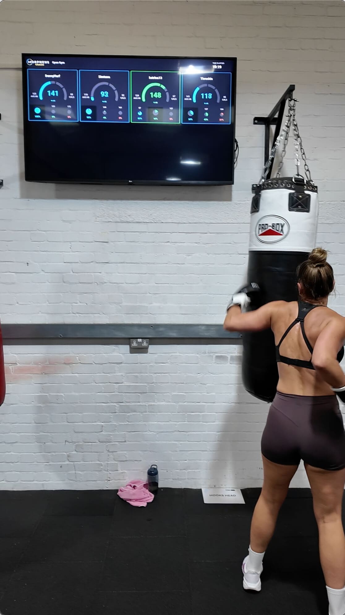 couple of women in a gym with a punching bag